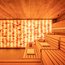 Moderne Sauna mit Holzbänken und beleuchteter Salzsteinwand