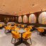 Modernes Restaurant mit orangen Stühlen und bunten Wandbildern